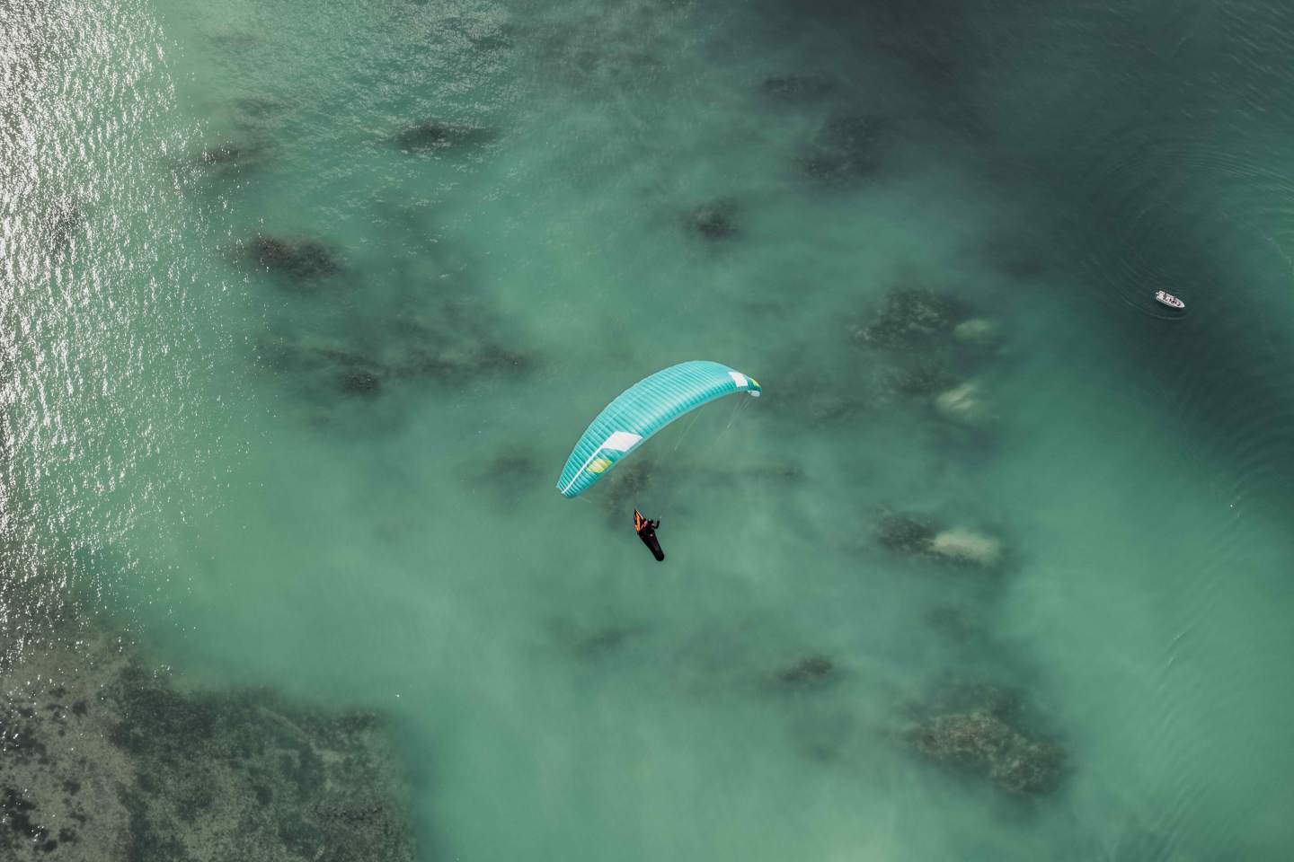 Pilote de parapente en montagne au coucher du soleil, aile posée, avant une nuit en bivouac