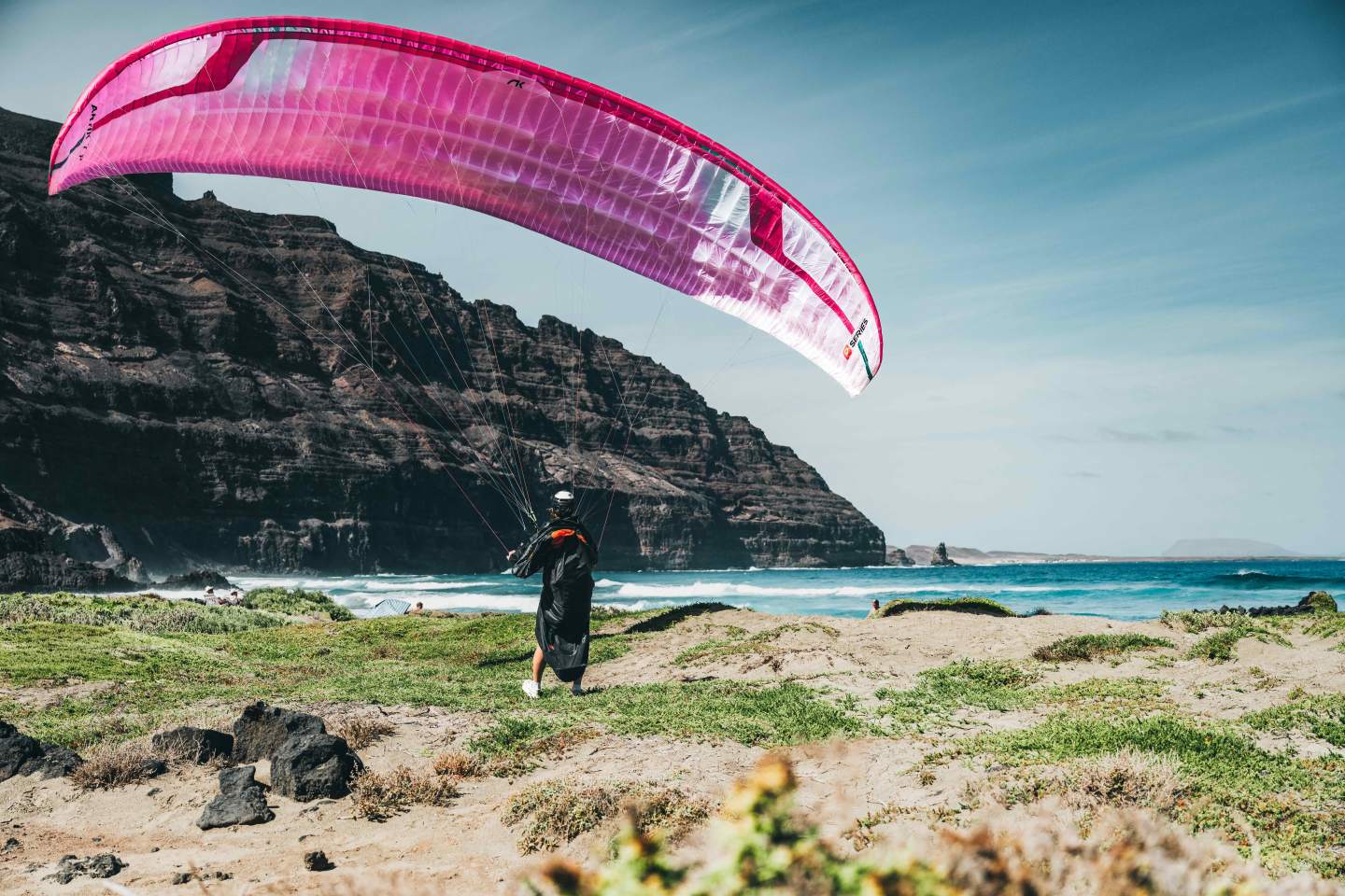 Aile de parapente légère en vol au-dessus des reliefs de montagne, le type de voile qu’on retrouve du rando-vol au cross.