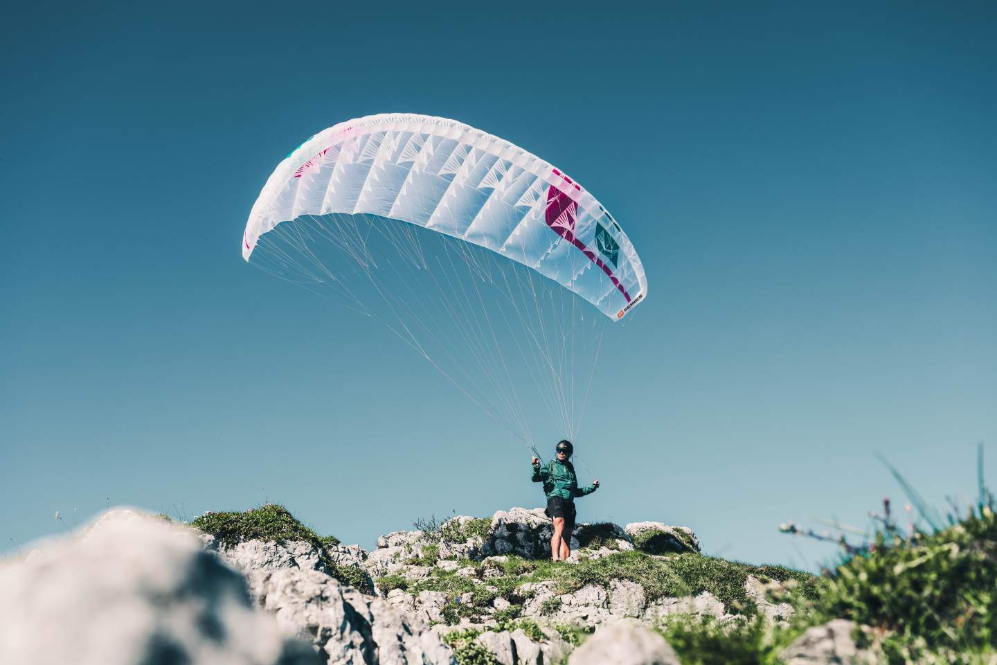 Décollage d’un parapente depuis un sommet herbeux